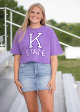 Load image into Gallery viewer, Person wearing a purple &#39;K State&#39; t-shirt standing outdoors on a bridge.
